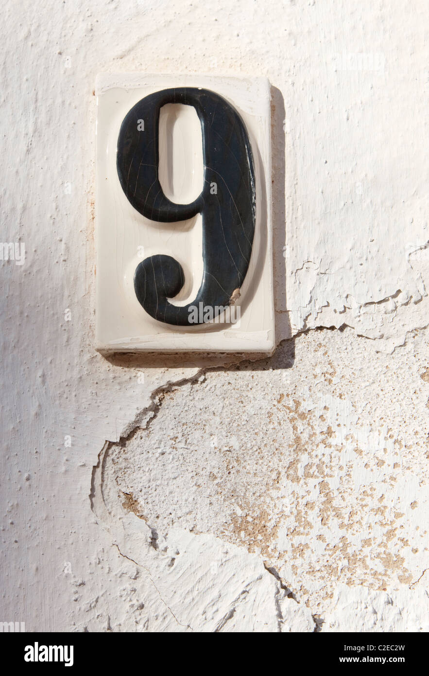 Numéro de céramique sur mur blanc neuf Banque D'Images