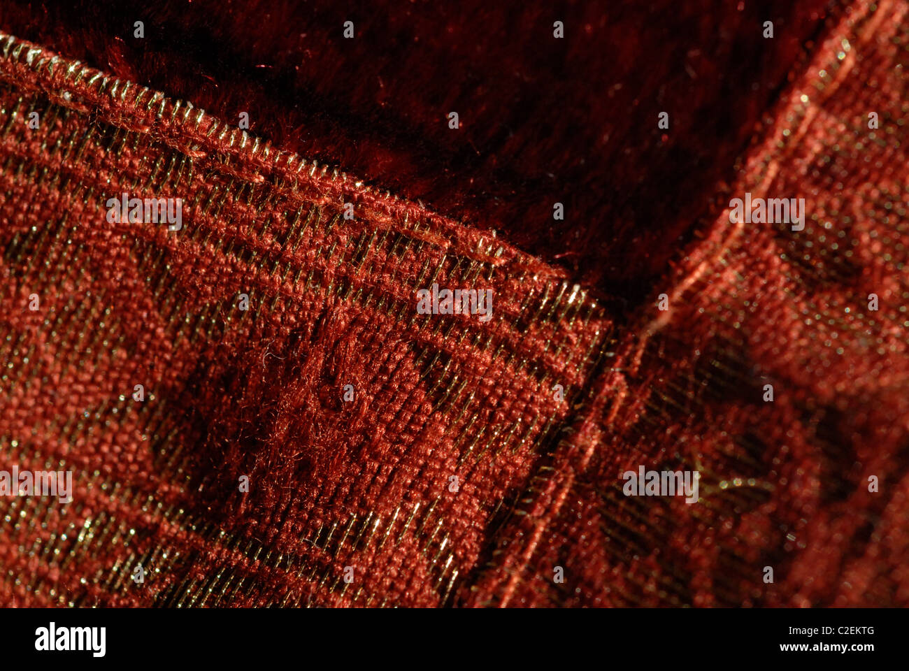 Détail d'un coussin décoratif fait de tissu décoratif rouge avec points d'or. Banque D'Images