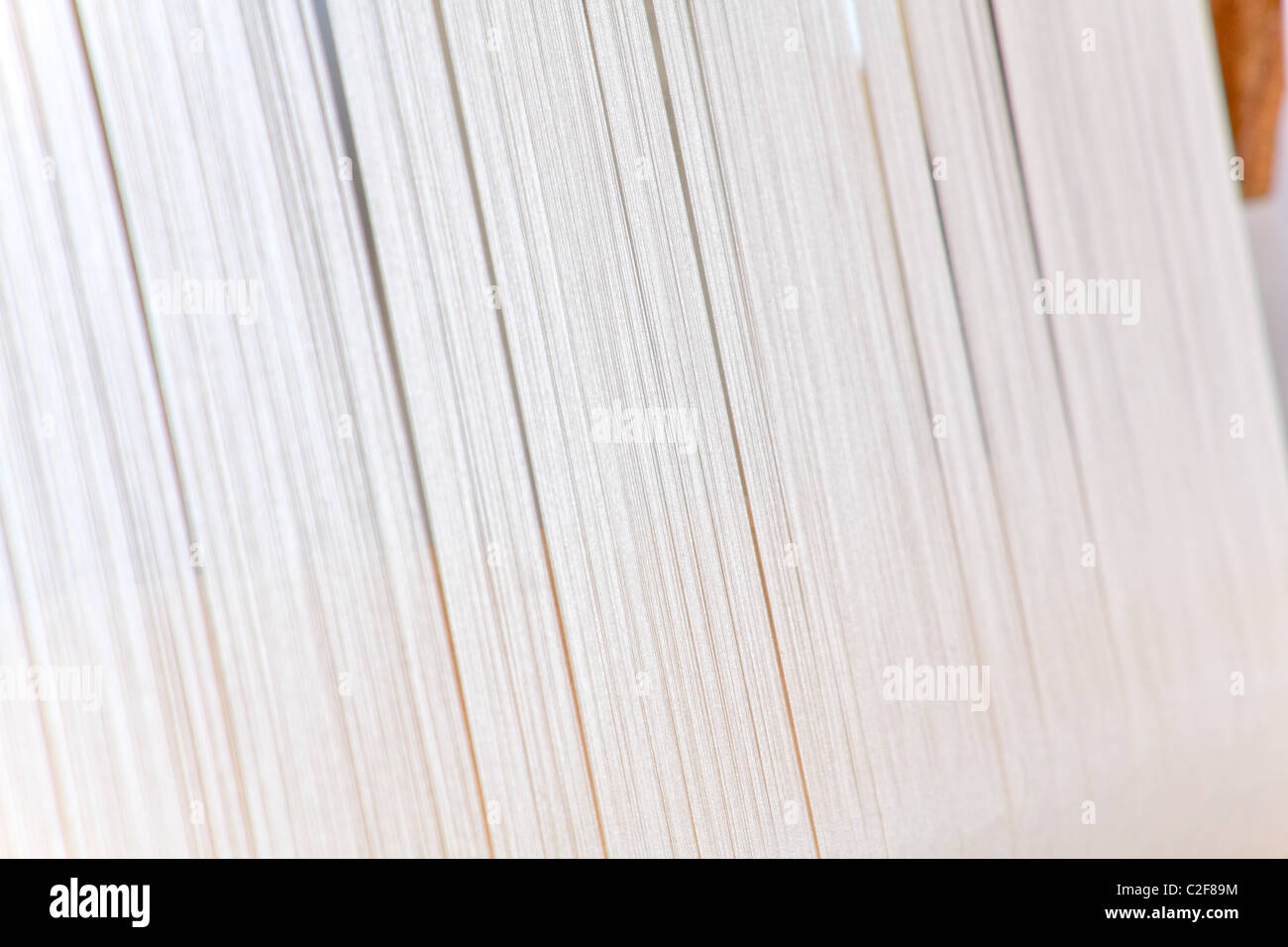 Cordes de tissu blanc dans un métier à tisser en bois Banque D'Images