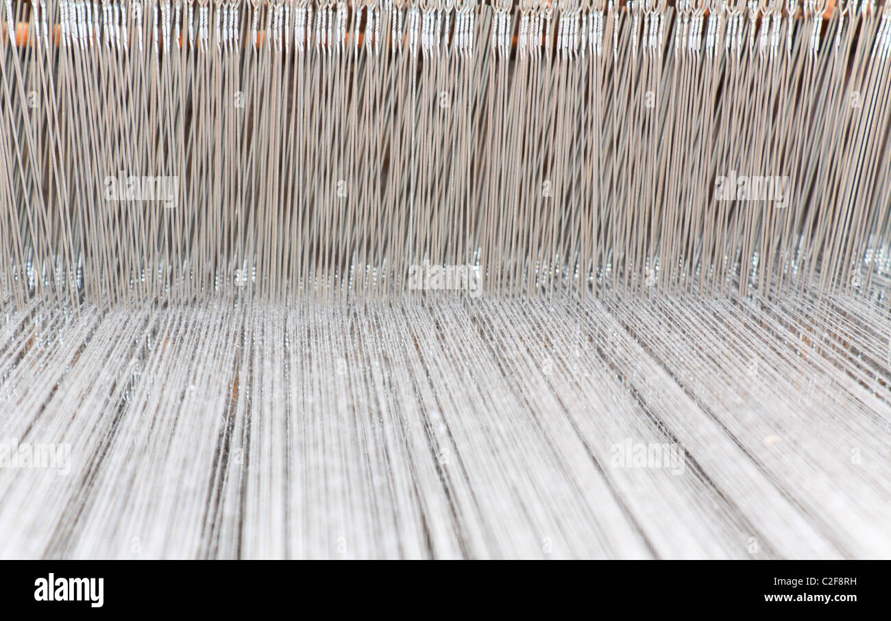 Cordes de tissu blanc dans un métier à tisser en bois Banque D'Images