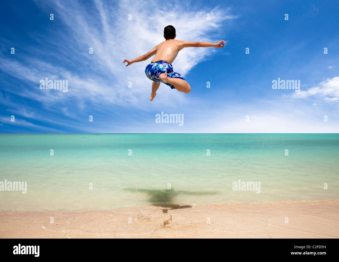 Happy young man jumping on the beach Banque D'Images