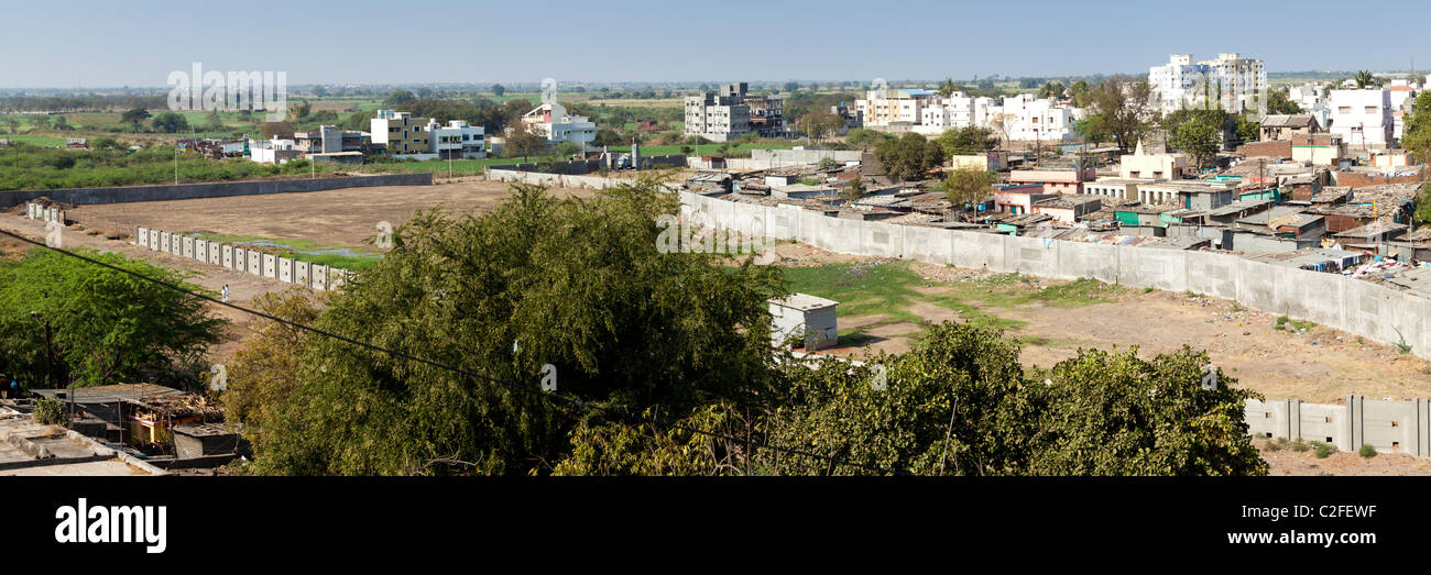 Panorama d'un bidonville indien. Un mur de béton l'empêche de se propager plus loin. Sholapur Maharashtra Inde Banque D'Images