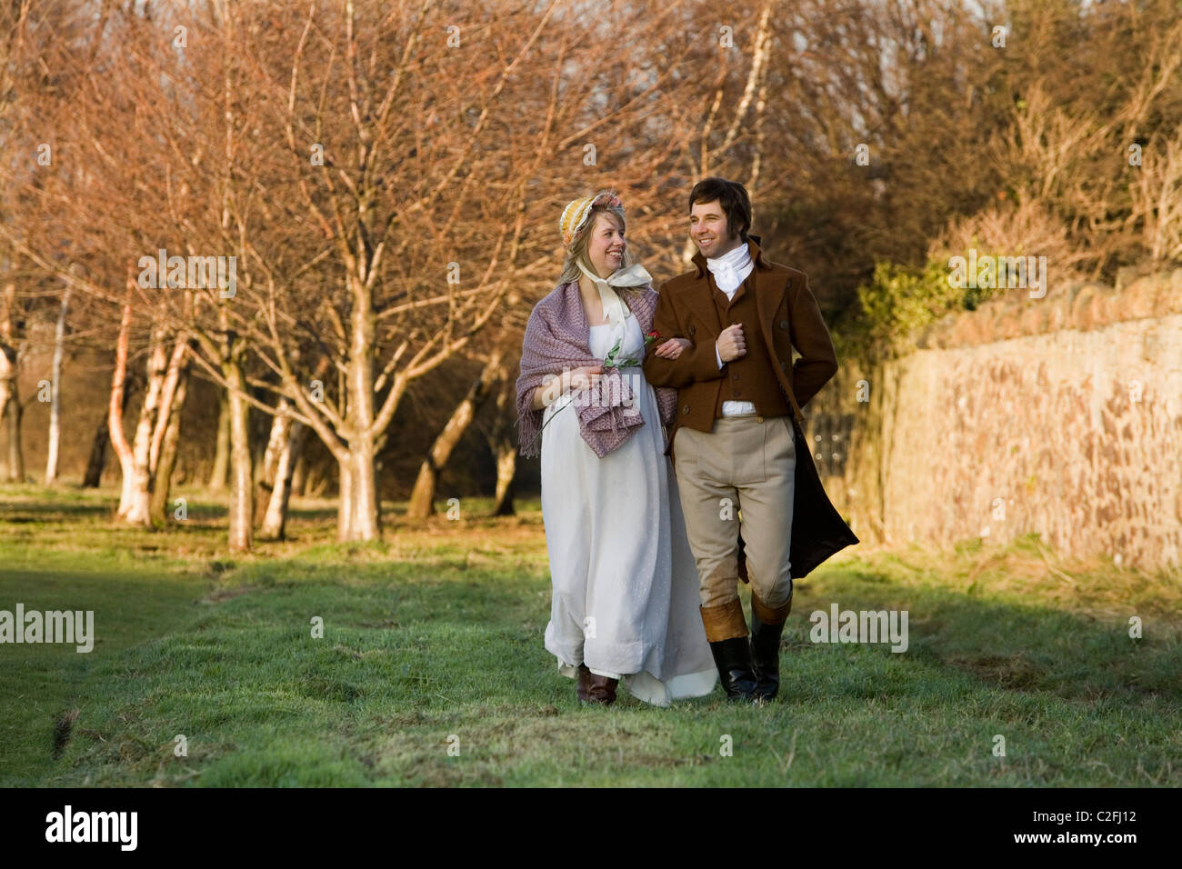 Un guide vêtu comme Robert Burns pose en caractère avec une jeune femme au cours d'une promenade romantique dans un parc. Banque D'Images