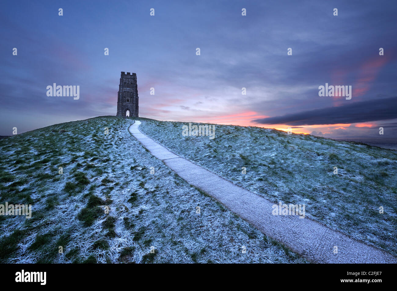 St Michael's tower au sommet de Glastonbury Tor sur un hiver froid comme le soleil du matin par des nuages épais Banque D'Images