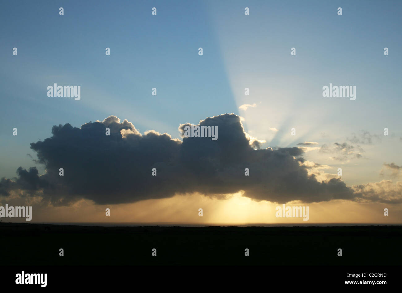 Soleil derrière un nuage, juste avant le coucher du soleil Banque D'Images