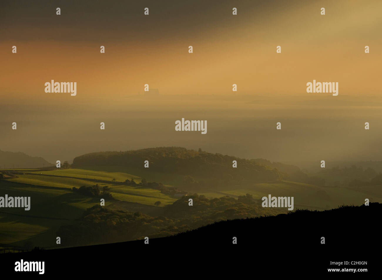 Tôt le matin, les rayons du soleil percent le ciel à travers près de Exmoor Porlock Banque D'Images