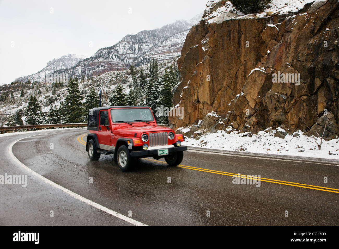 Jeep rouge qui circulent sur l'autoroute 550, le Million Dollar Highway, entre Ouray & Silverton, Colorado, USA Banque D'Images