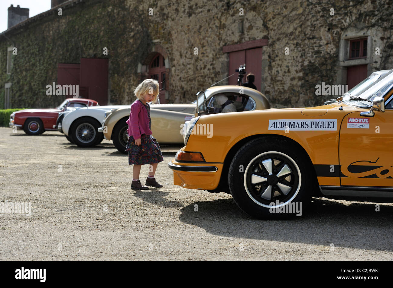 Stock photo d'un jeune enfant regardant un vintage voiture de sport. Banque D'Images