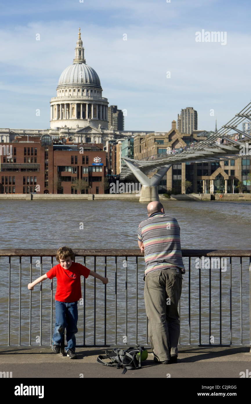 Homme avec enfant dans la rive sud de la Tamise, le Millennium Bridge et St Paul's Cathedral, London, England, UK Banque D'Images