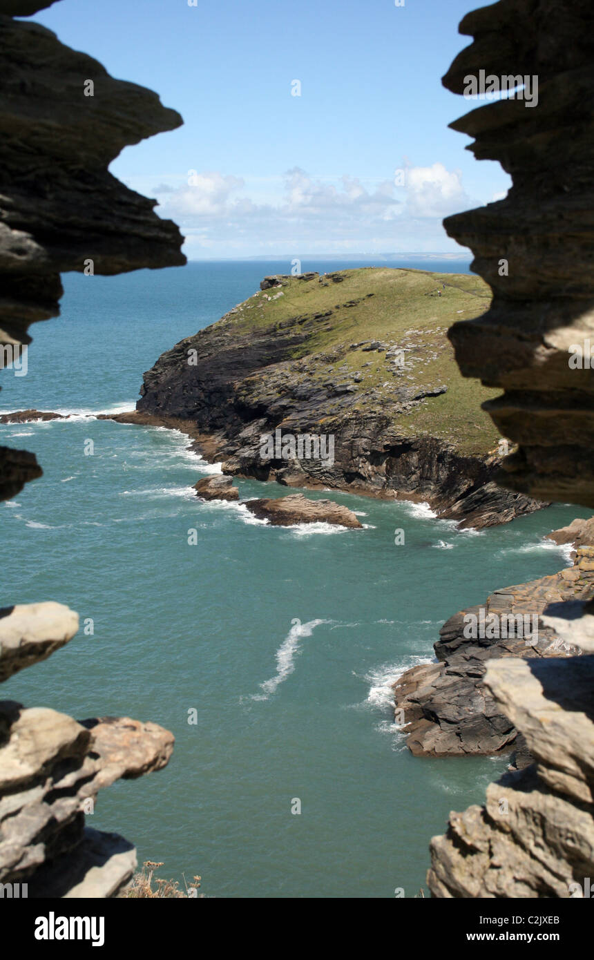 Vue sur la mer et pointe à travers une fenêtre en pierre à Tintagel, Cornwall, Angleterre Banque D'Images