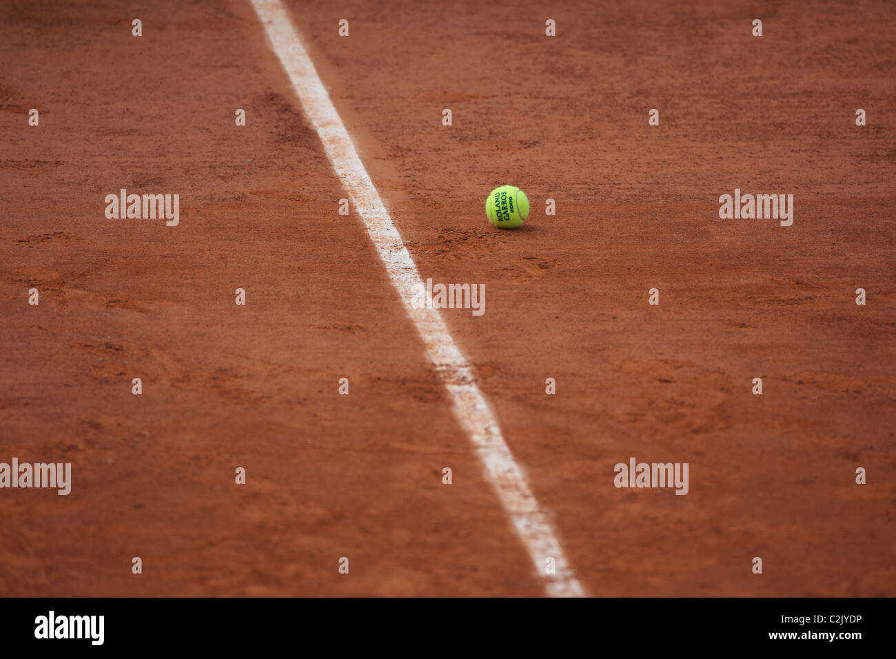 Une balle de tennis sur la terre battue de Roland Garros avant le début de l'Open de tennis français à Paris, France. Banque D'Images