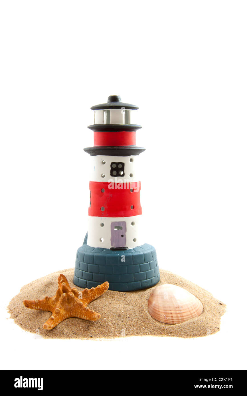 Phare sur le sable avec des coquillages isolated over white Banque D'Images