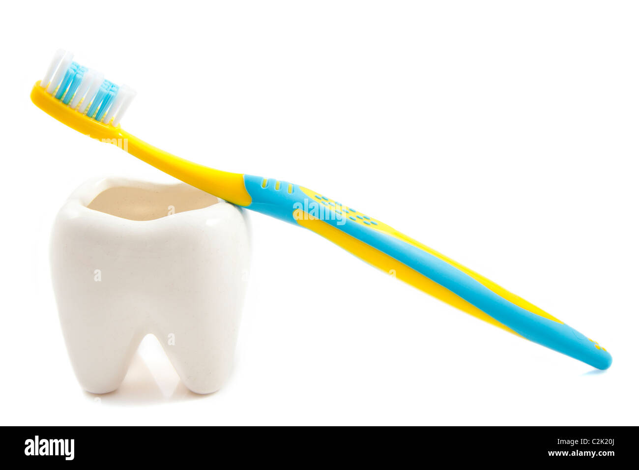 Brosse à dents bleu jaune sur une molaire isolée sur fond blanc Banque D'Images