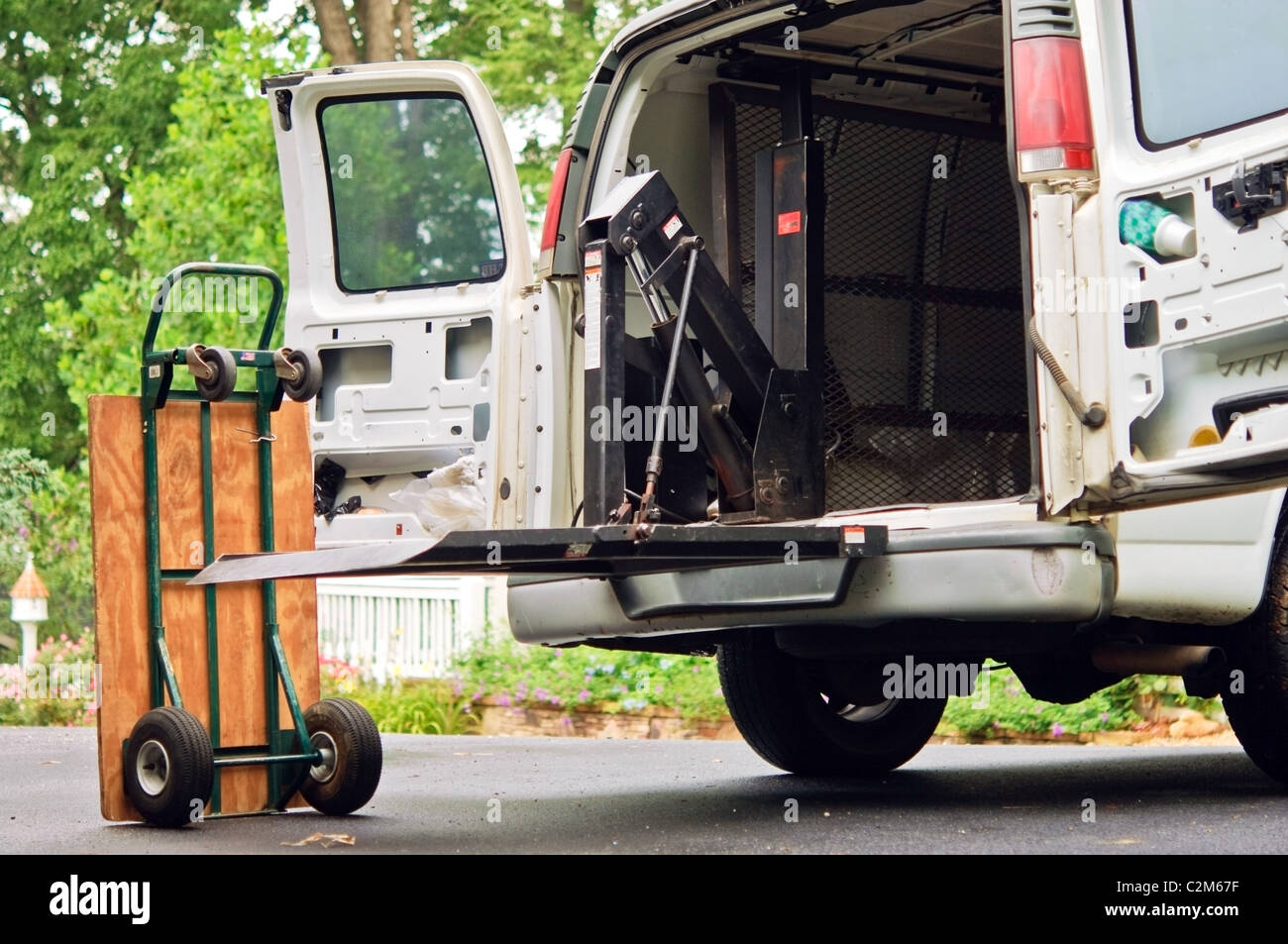 Un petit camion de livraison avec de l'équipement dans une entrée. Banque D'Images