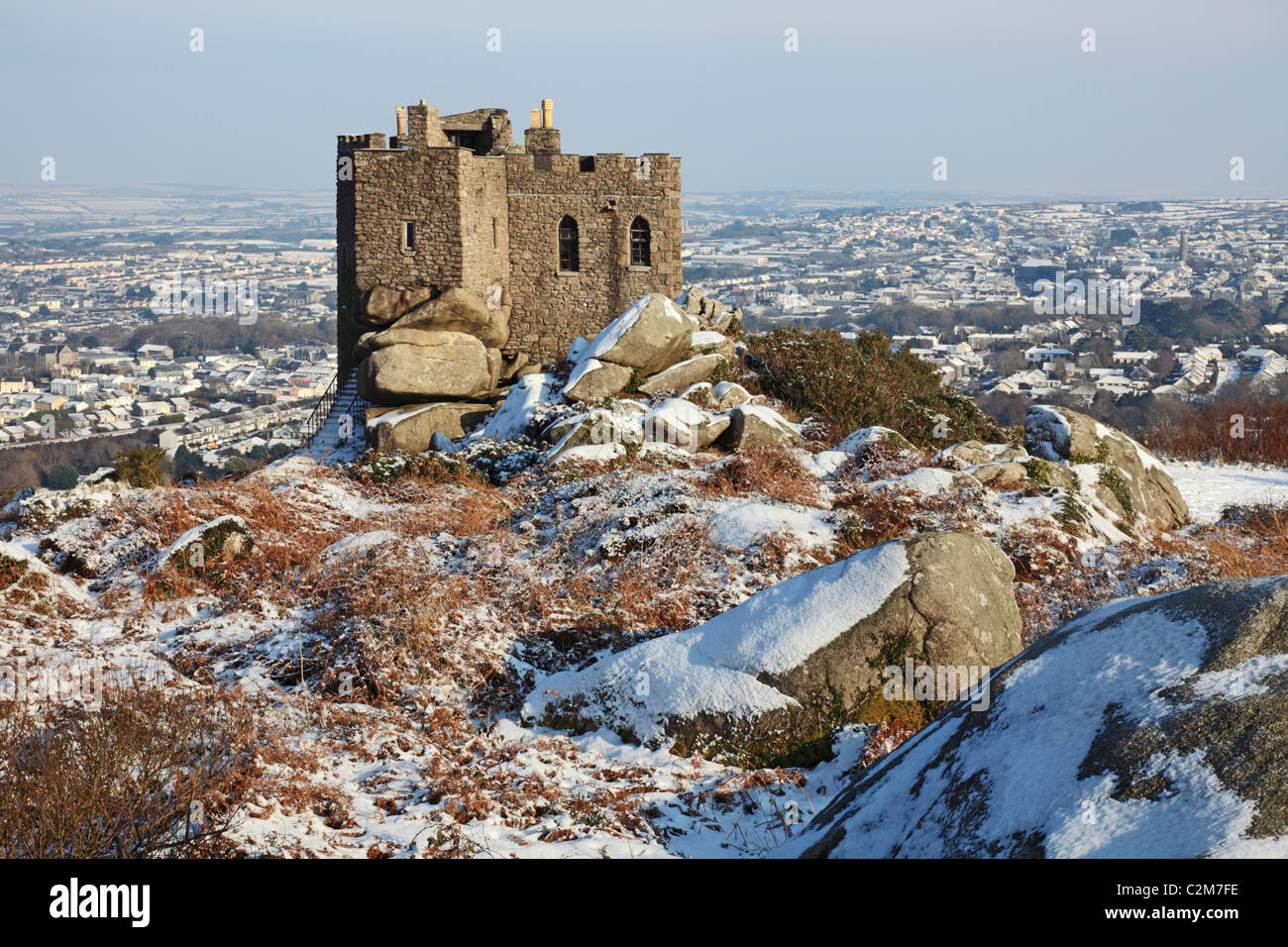 Carn Brea château capturé sur un matin avec l'hiver la neige a couvert la ville de Truro en arrière-plan Banque D'Images