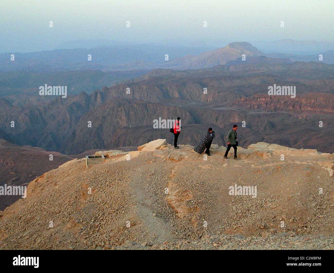 3 chiffres dans la distance de marche sur une falaise surplombant les canyons en début de matinée Banque D'Images