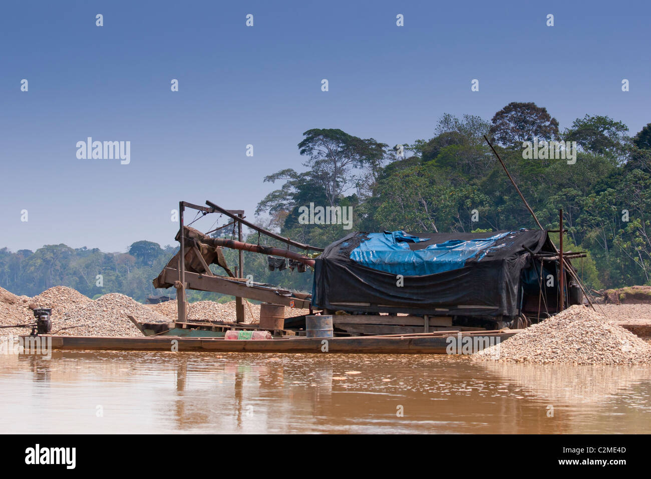 L'exploitation aurifère illégale sur la rivière Tambopata dans l'Amazonie péruvienne. La mine de bateaux pour l'or et de sable alluvionnaire libérer du mercure. Banque D'Images