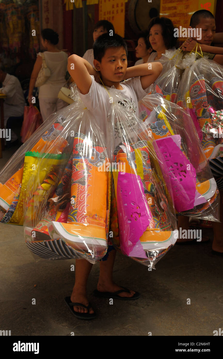 Jeune garçon transportant des marchandises pour offrir durant le festival végétarien à San Jao Sieng Kong culte , wat sung heng yee, Bangkok Banque D'Images
