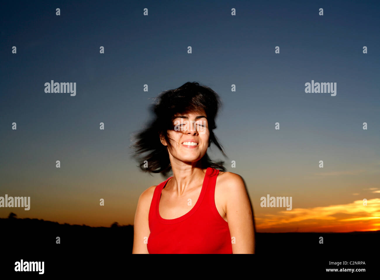 Femme latine avec les cheveux foncés et le coucher du soleil Banque D'Images