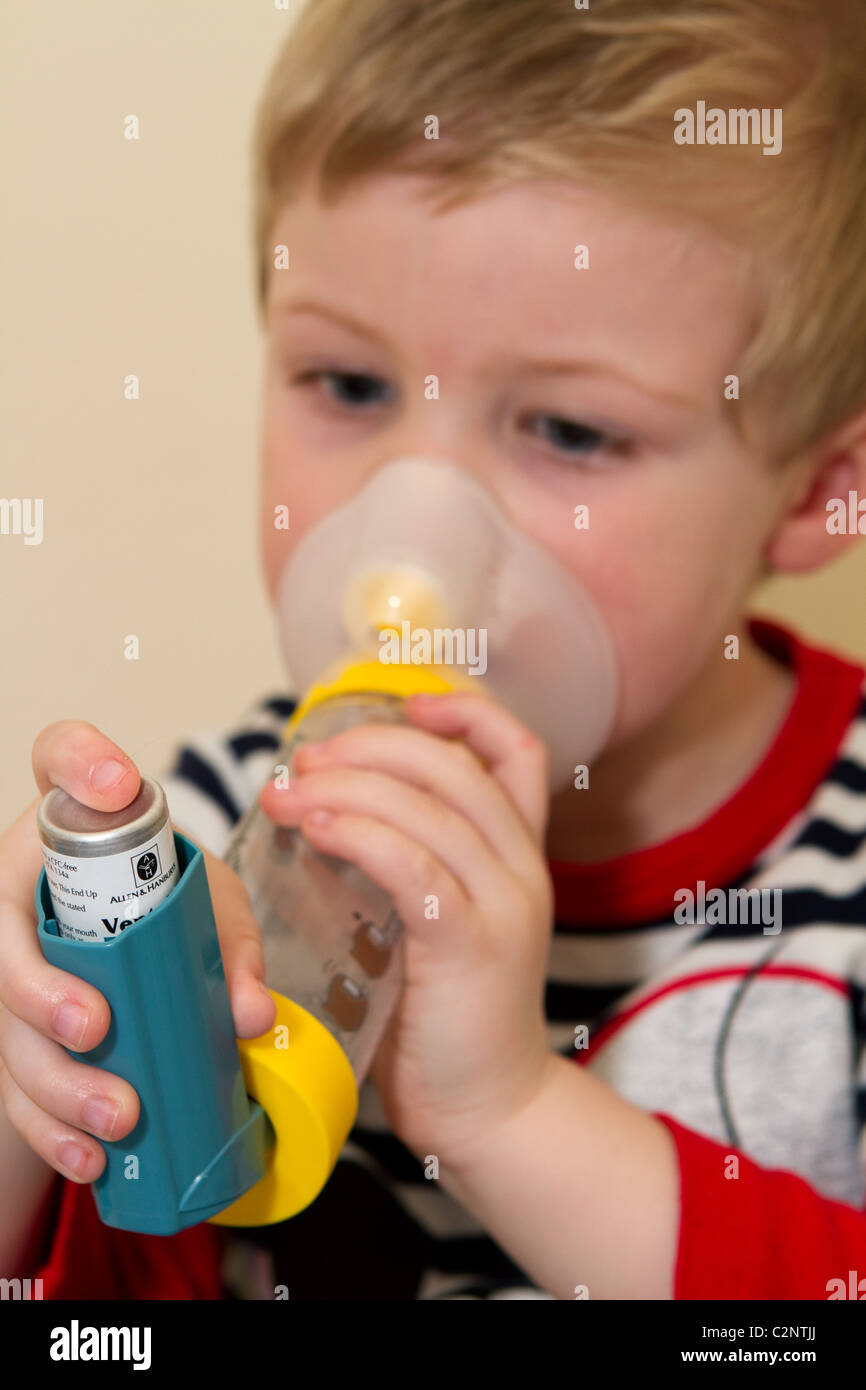 Jeune garçon à l'aide d'un inhalateur d'asthme et de l'entretoise. Banque D'Images
