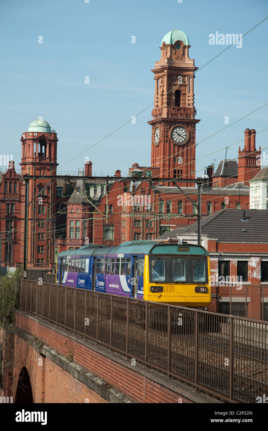 Northern Rail train circulant à travers le centre de Manchester, l'hôtel Palace dans l'arrière-plan. Banque D'Images