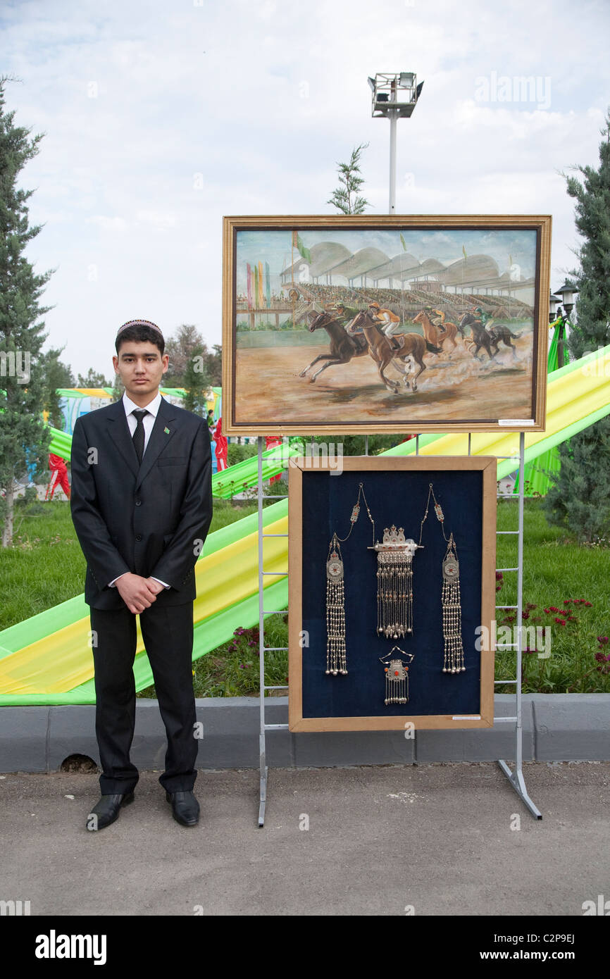 Un étudiant d'art se trouve à côté de son affichage à l'Hippodrome au Turkménistan à l'occasion de la journée de cheval turkmène Banque D'Images