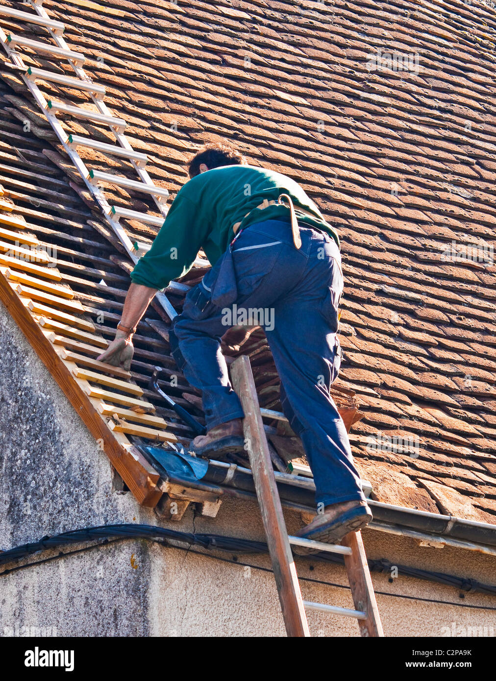 En descendant de l'ouvrier sur l'échelle de l'échelle de toiture - France. Banque D'Images