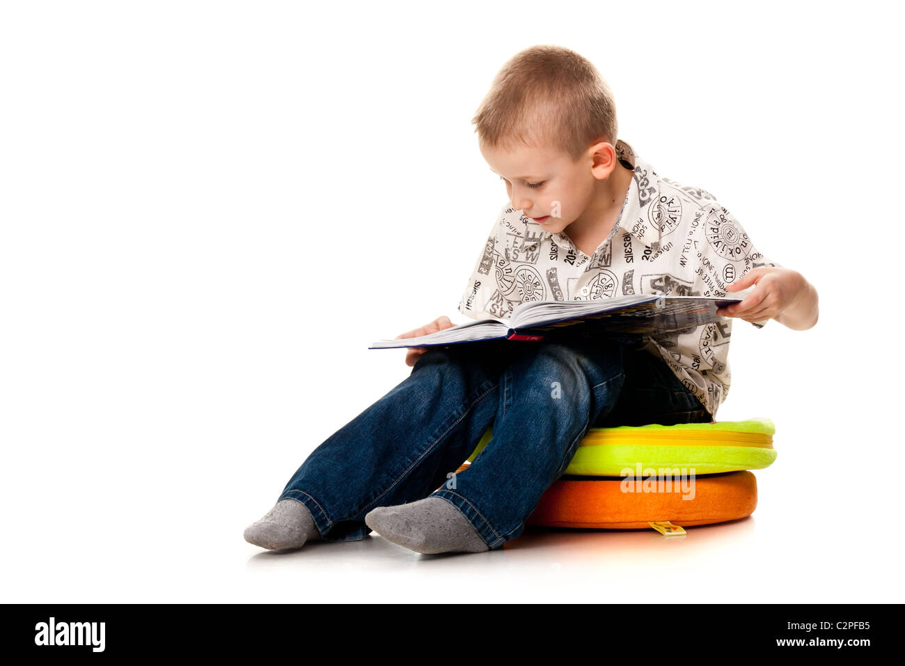 Cute boy reading a book isolated on white Banque D'Images