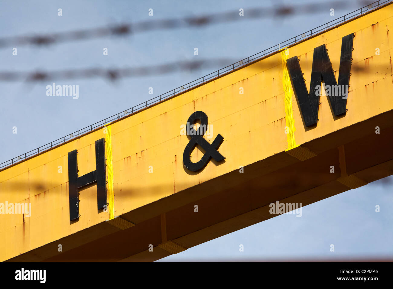 Harland and Wolff de Belfast grues de chantier naval historique de l'Irlande du Nord logo uk vue à travers des barbelés Banque D'Images