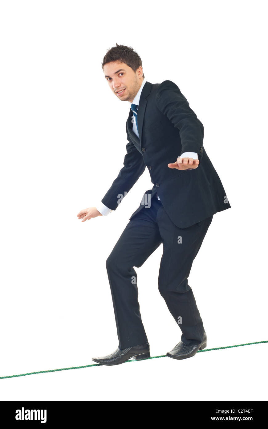 Young businessman walking on tightrope et essayant de garder son équilibre isolé sur fond blanc Banque D'Images