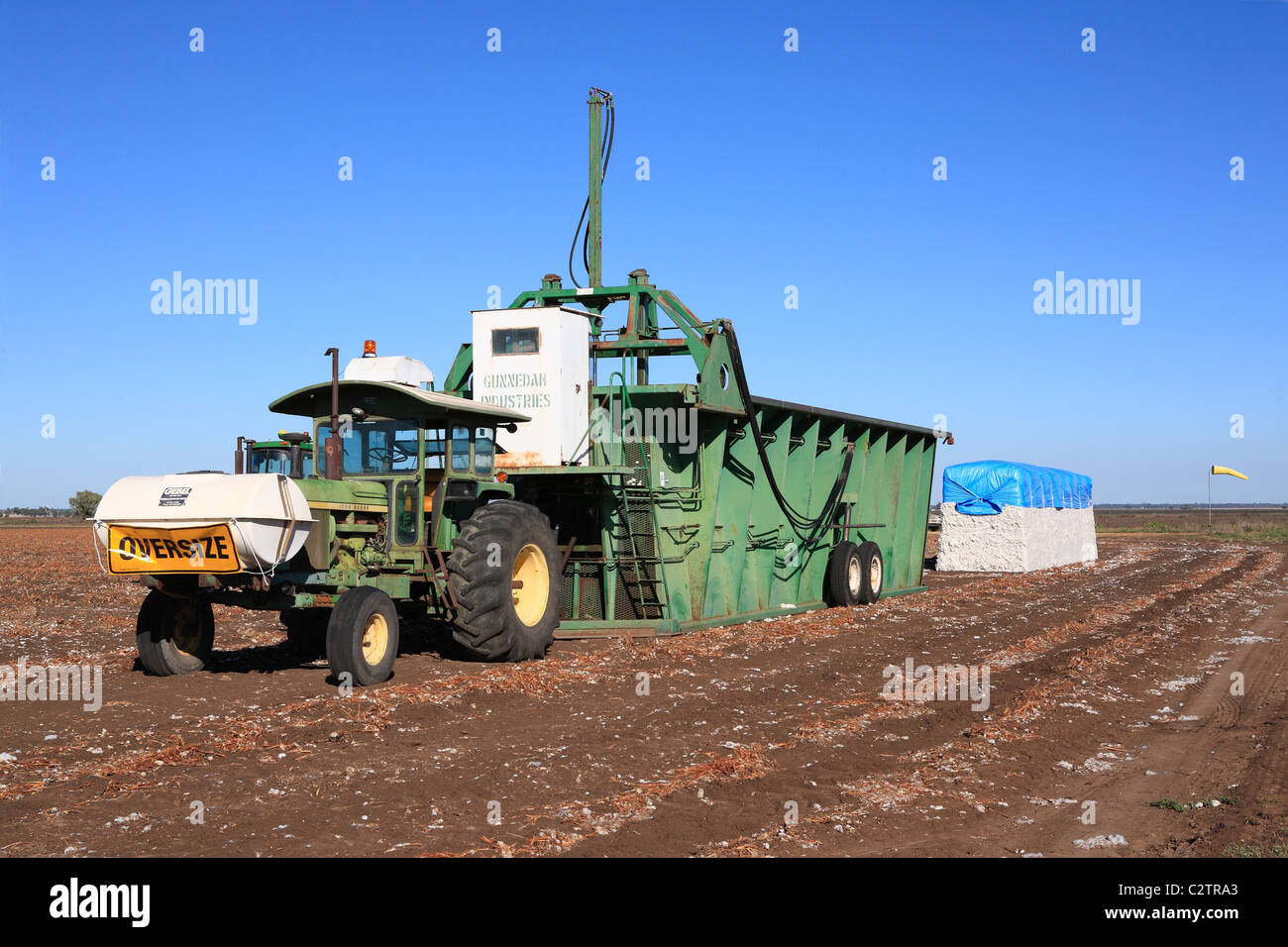 Tracteur John Deere est relié à un module builder, coton ou le compactage de machine, avec un module de coton. Banque D'Images