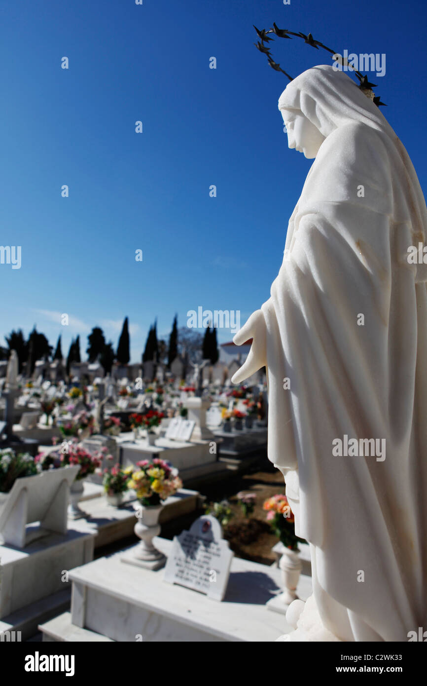 Une sculpture en marbre de la Vierge Marie fait partie d'une tombe dans
