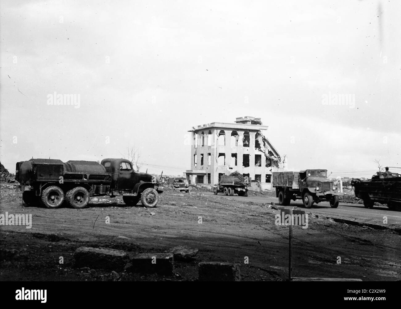 Bâtiment détruit et les véhicules de l'armée dans la photographie faite sur Okinawa en vers 1945 après l'invasion américaine. Banque D'Images