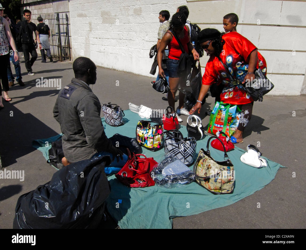 Paris, France, les touristes de shopping dans les boutiques touristiques dans quartier de Montmartre, des immigrants africains, l'homme de vendre des sacs à main contrefaits sur street Banque D'Images