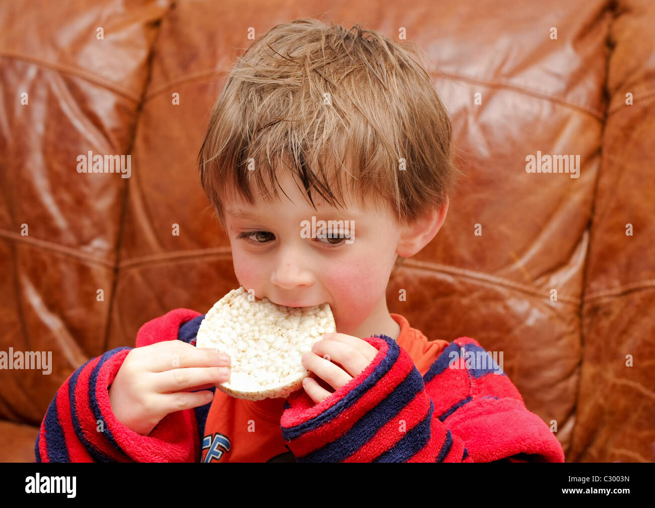 Petit garçon de manger un gâteau de riz Banque D'Images