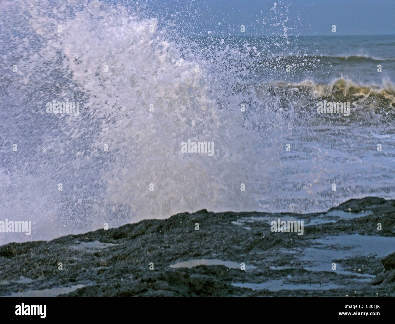 Éclaboussures des vagues d'eau sur un rocher dans la mer, Velneshwar, Guhagar, Ratnagiri, Maharashtra, Inde Banque D'Images