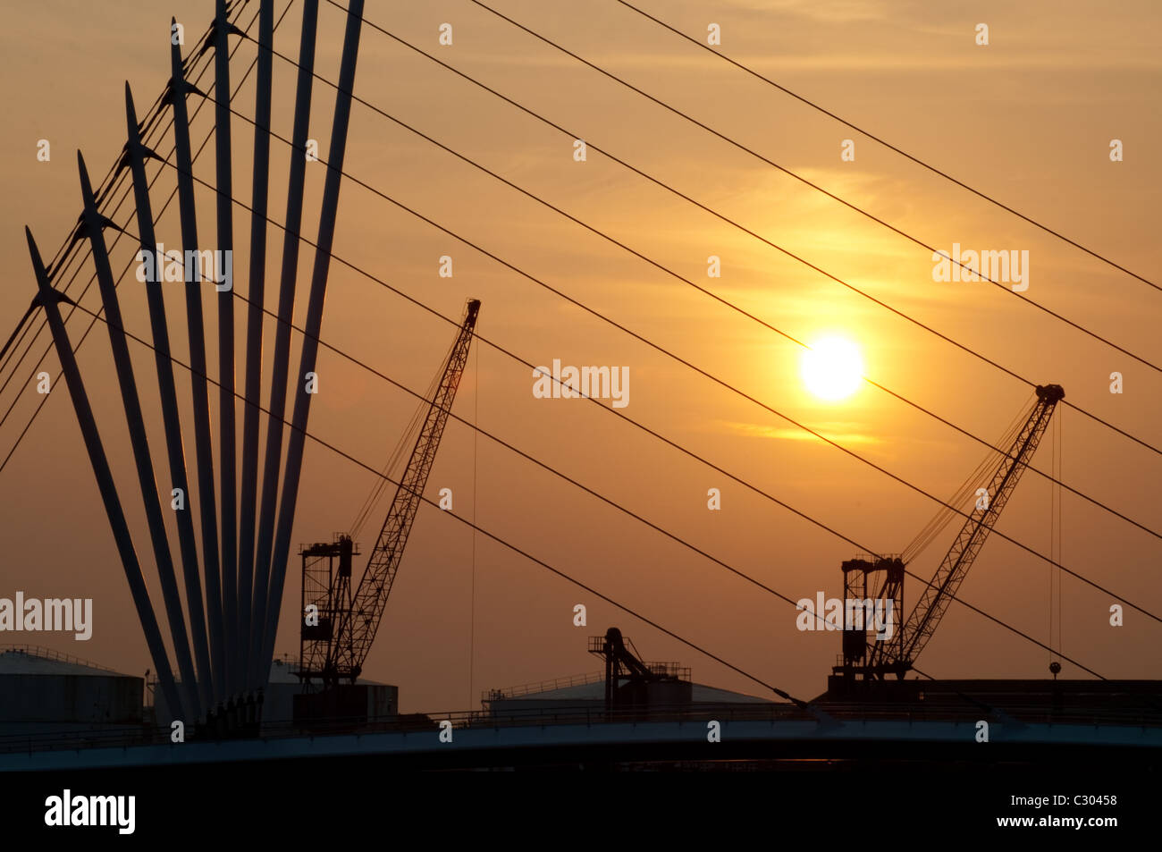 Le soleil derrière la nouvelle passerelle à Media City, les grues un rappel de l'histoire industrielle comme un port important. Banque D'Images