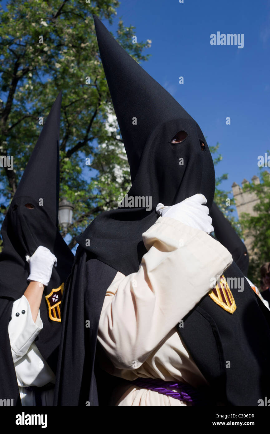 Les Pénitents à capuchon (Nazarenos) se rassemblent pour Séville Semana Santa annuel passion Pâques processions. Banque D'Images