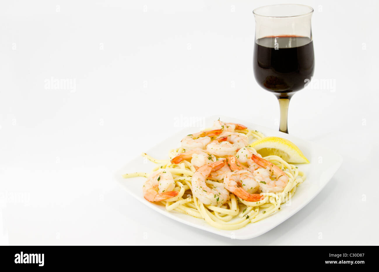 Langoustines Crevettes aux fines herbes et citron coupe sont desservis sur jeté d'olive spaghetti avec du vin rouge en bonne santé Banque D'Images