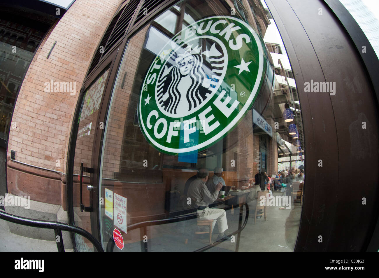 Un logo Starbucks vu dans la fenêtre d'un café Starbucks dans le quartier de l'East Village à New York Banque D'Images