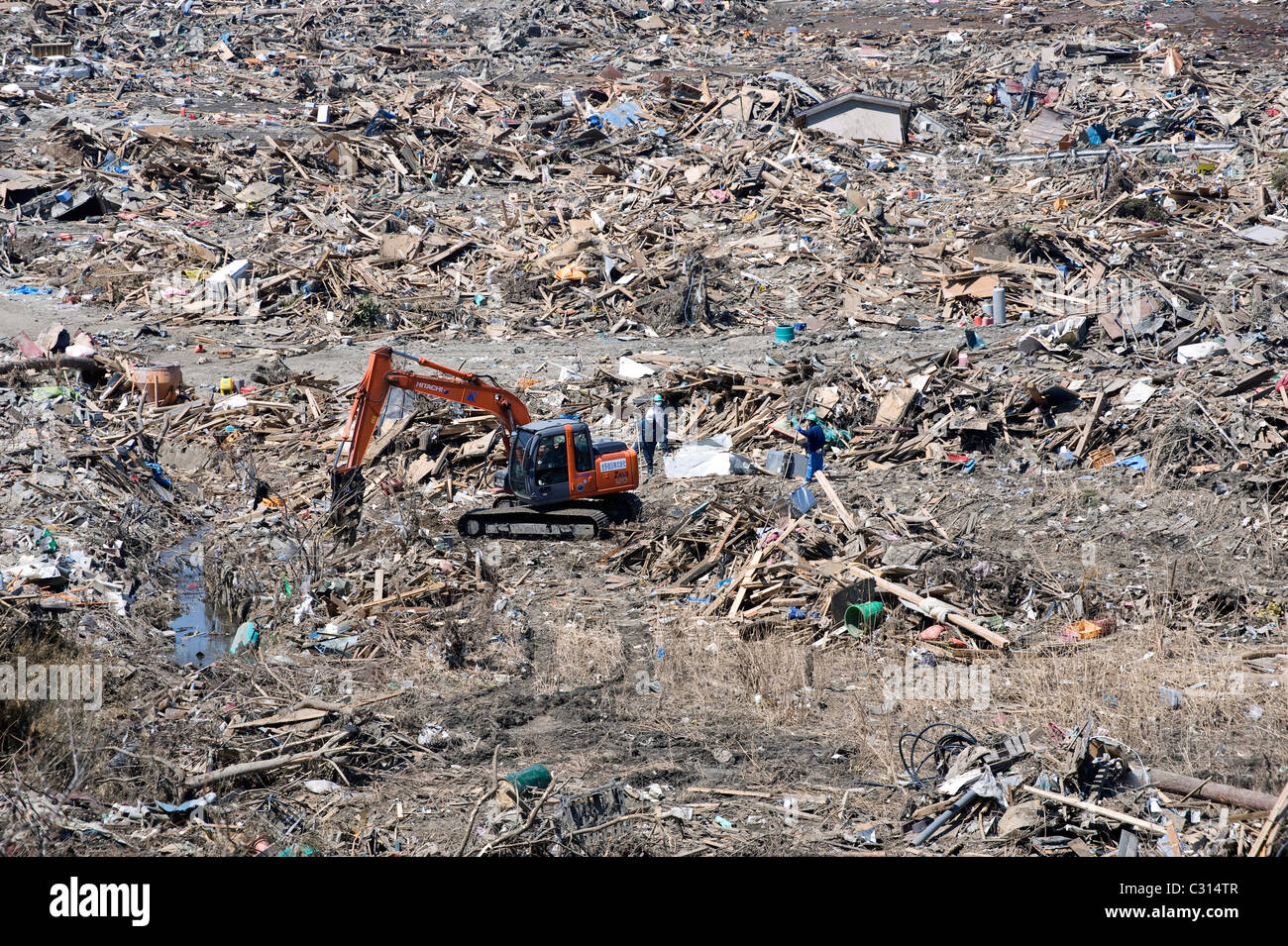 Un creuseur recueille des gravats dans la ville détruite par le tsunami de Rikuzentakata, Iwate Prefecture, Japan Banque D'Images