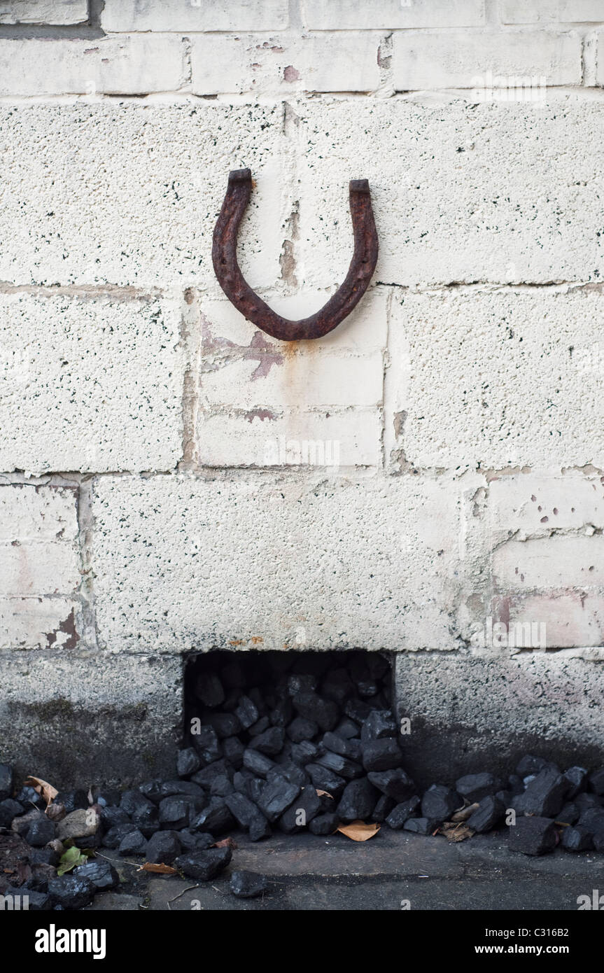 Horseshoe verticale invitant bonne chance, placé sur un bunker du charbon dans le jardin d'une maison de Northumberland, en Angleterre, UK. Banque D'Images