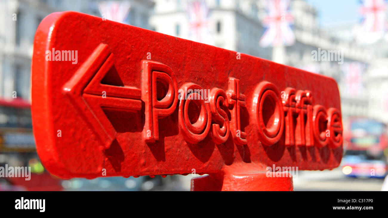 Gros plan du bureau de poste rouge, flèche pointant vers le panneau de direction sur le dessus du montant, drapeau Union Jack, au-dessus de Regent Street West End London England Banque D'Images