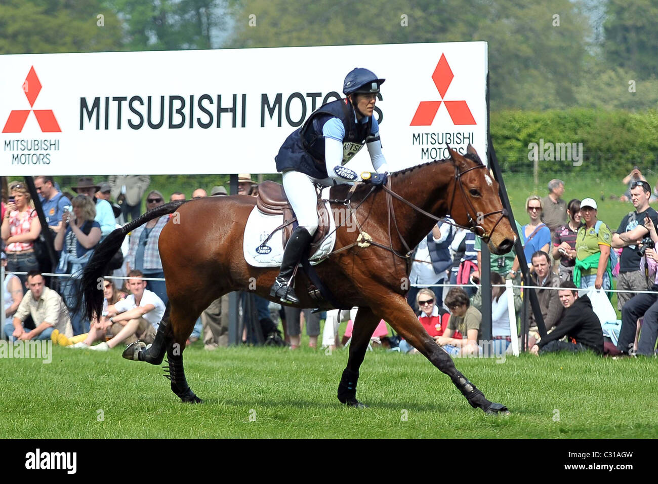 Anna Warnecke (GER) équitation TWINKLE BEE galops passé la foule et la Mitsubishi signe. Mitsubishi Badminton Horse Trials Banque D'Images