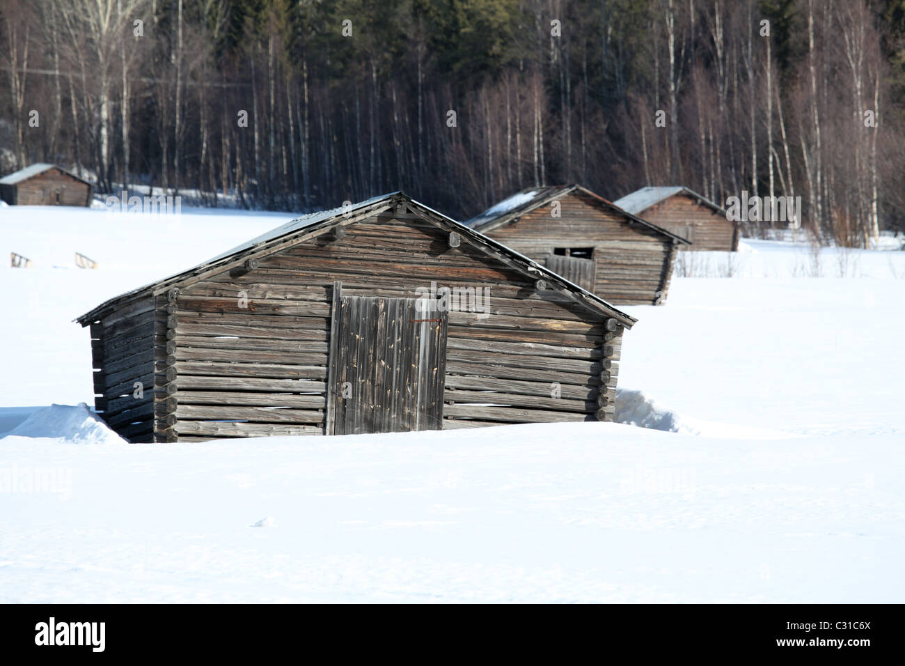Les huttes en bois traditionnel dans le champ couvert de neige, Boviken, près de l'Skellaftea, le nord de la Suède Banque D'Images