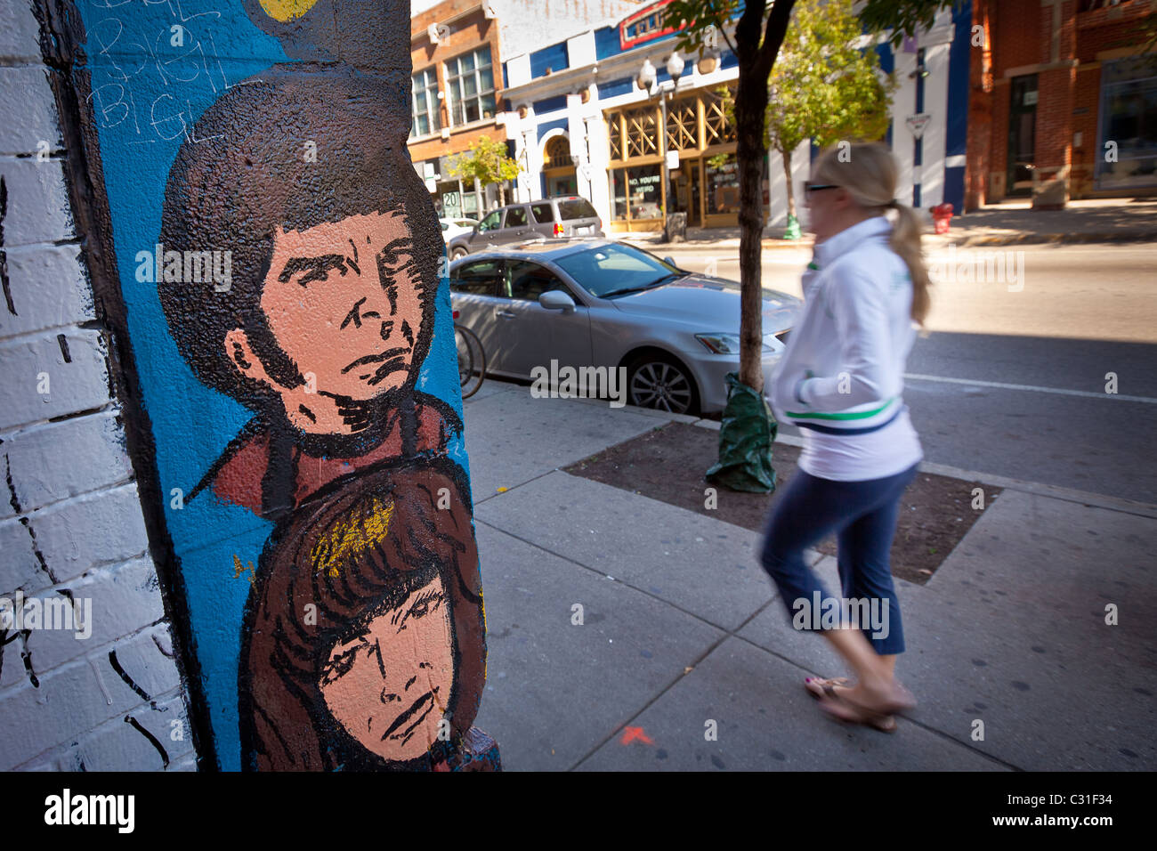 Une personne passe l'art de mur à la mode dans le quartier branché de Wicker Park à Chicago, IL, USA. Banque D'Images