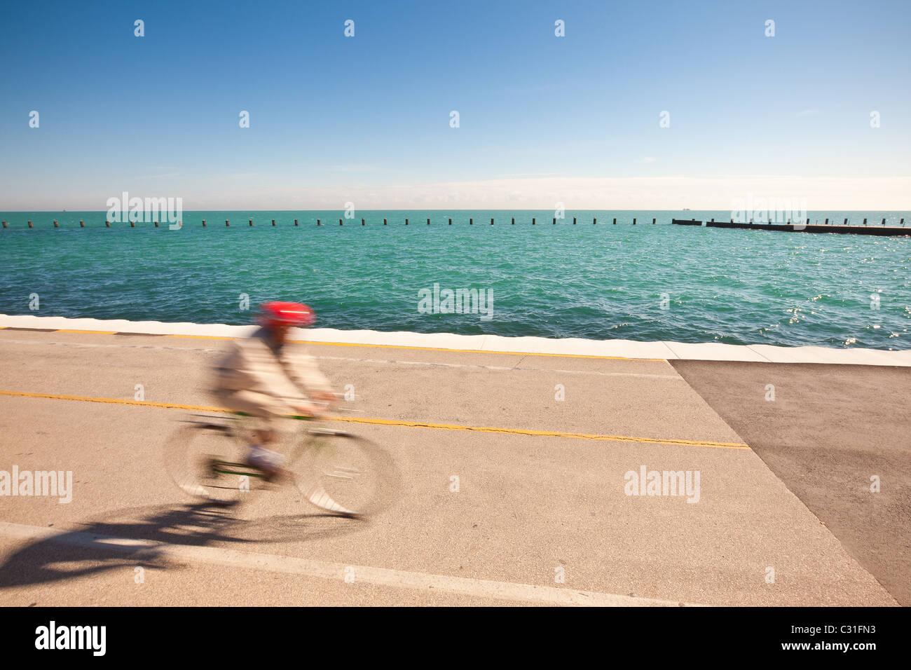 Un cycliste rides le long du lac Michigan dans le centre-ville de Chicago, IL. Banque D'Images