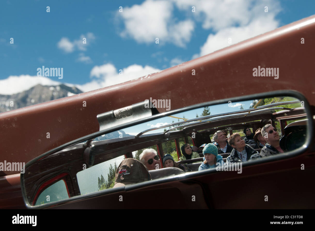 Les passagers dans le bus rouge miroir, Passe-à-la-Sun Road, Glacier National Park, Montana. Banque D'Images
