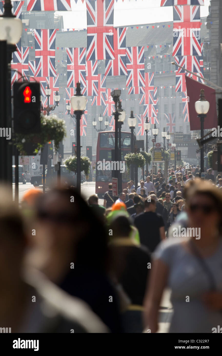 Union Jack Bunting décore Regent Street pour célébrer le mariage royal, tandis que des foules de clients remplissent le quartier commerçant animé de Londres, au Royaume-Uni Banque D'Images