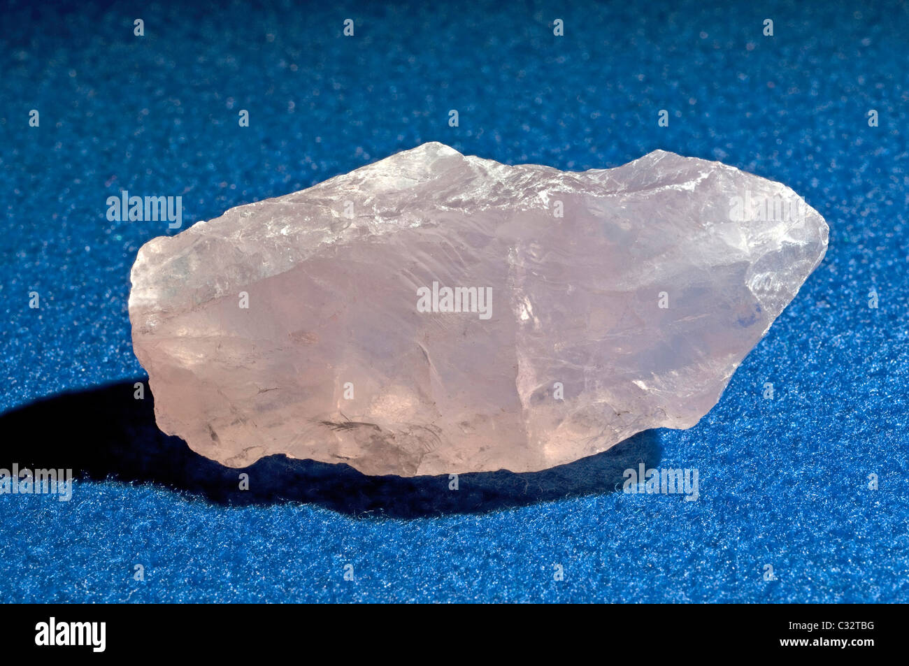 Quartz Rose, pièce non coupée, studio photo sur un fond bleu. Banque D'Images